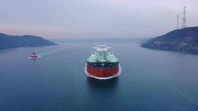 有引航船的大型原油油轮在海峡中航行。