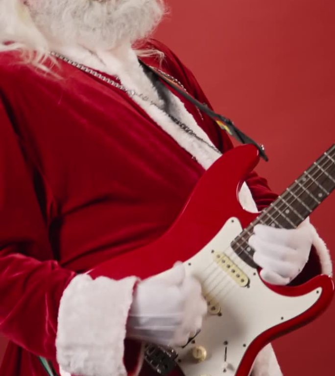 戴墨镜的圣诞老人在红色背景上弹奏电吉他