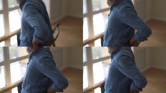 剪辑的照片显示，70多岁的老人从椅子上站起来时，感到腰痛。不健康的成熟退休男性