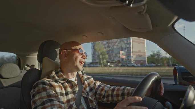 一位秃顶的中年男子在出差或旅游时开着租来的汽车