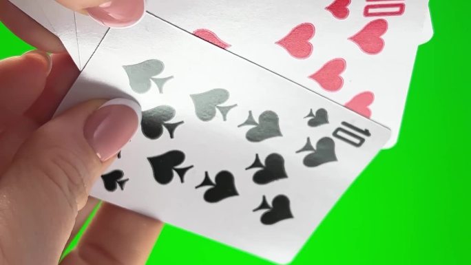 女性的手，法式美甲。女人整理卡片，检查折叠，像扇子一样展开同一套衣服剩下的四张卡片，手拿着四打卡片，