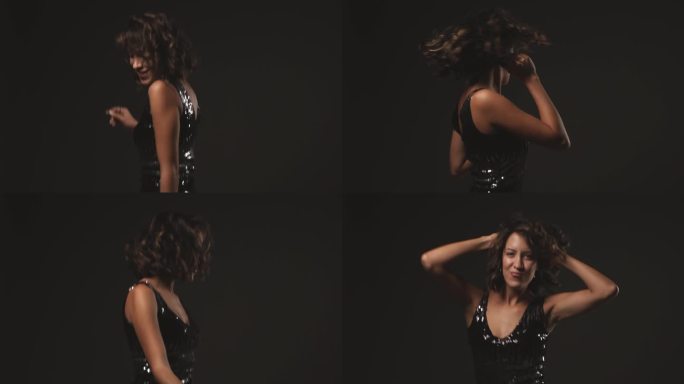 年轻帅气的黑发女郎在镜头前微笑，在黑色背景下跳舞