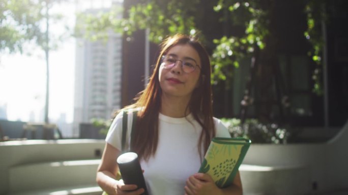 拿着旅行杯走在大学里的学生