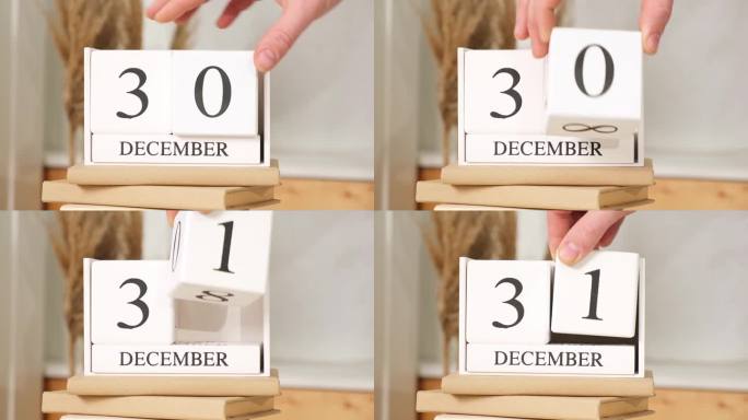 男人把12月31日写在日历上。白色方块日历显示日期31月12日