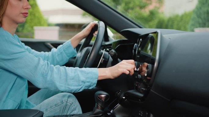 一位女士在车内用触摸屏设置导航gps应用程序的特写镜头。