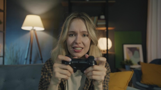 晚上在公寓里用操纵杆玩电子游戏的情绪化女士的肖像
