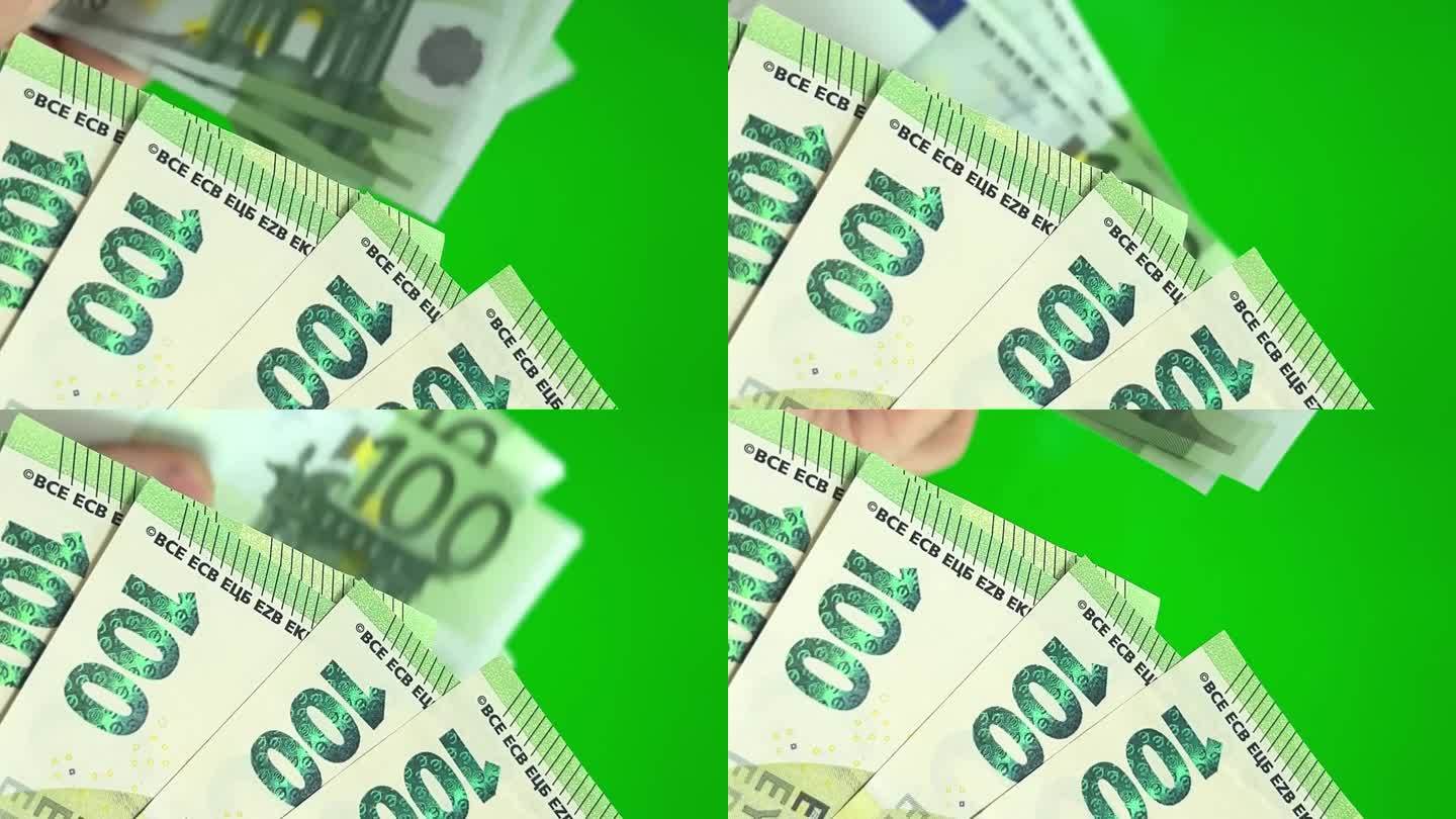 欧元特写绿色背景色度键新钞在旧钞前的背景中计数旧币换新币赢计数钱扇形出100欧元纸币