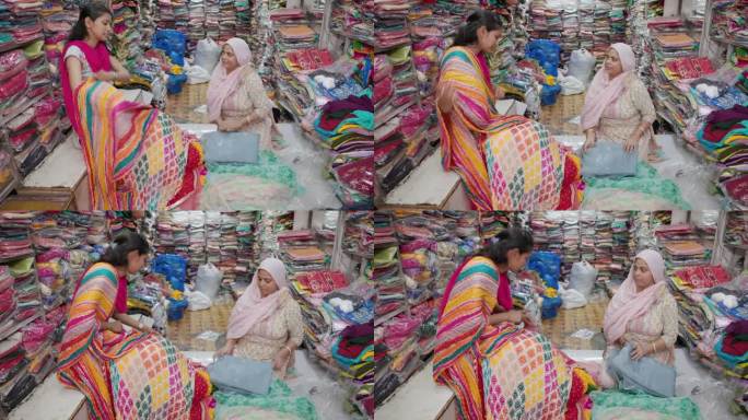 在印度斋浦尔，一名年轻的印度妇女正在购买传统的围巾
