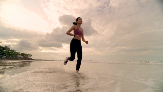 女人在沙滩上跑步女性健身晨跑美景沙滩