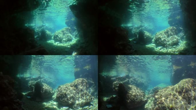 摄像机通过水下隧道移动到石头上方的太阳光线。