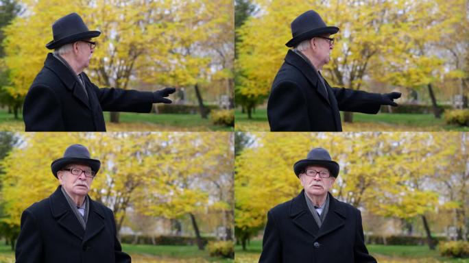 一位爷爷走过一个美丽的秋天公园，他戴着一顶黑帽子，穿着大衣，讲述着他童年的回忆。