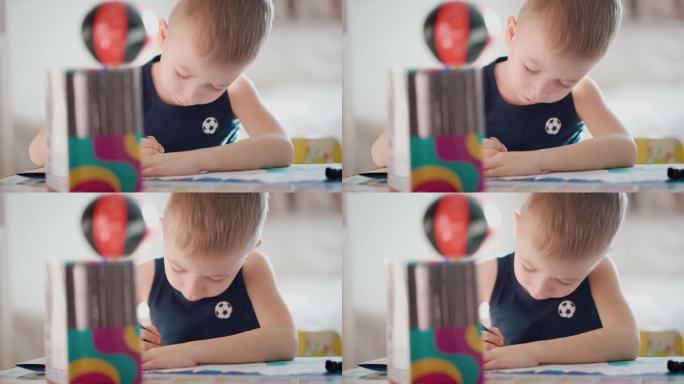 绘画。小男孩在家里用铅笔涂色。孩子在桌上画画。儿童人格心理学。帮助获得自信。创意与教育理念。