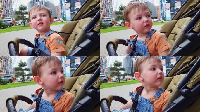 一个小男孩坐在婴儿车里四处张望，等着他的妈妈。一个悲伤的孩子看着等待的父母两岁的男孩(两岁)