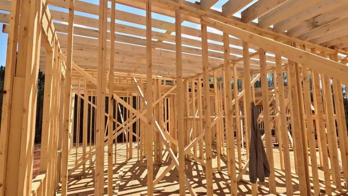 在工地上，有几根木棒框架梁来搭建新房子