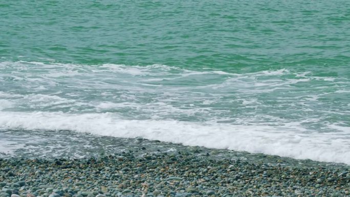 自然元素。白色的波浪泡沫袭击了美丽的海滩。电影放松的背景。缓慢的运动。
