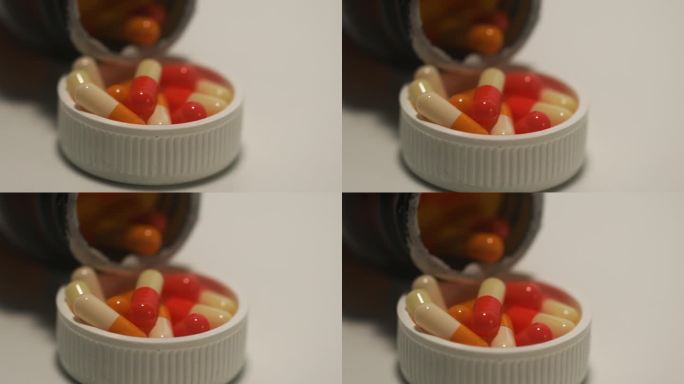 视频放大了许多橙色药丸胶囊进入药瓶的画面。