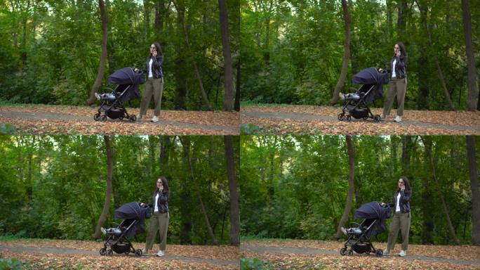 一位年轻的母亲一边讲电话，一边摇着婴儿车里的孩子。一位戴眼镜的妇女在秋天的森林里打电话。4 k