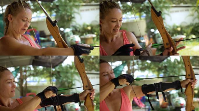 女子在射击场拿着弓。假期积极休闲，到亚洲旅游。泰国游客户外娱乐场所。在射击场练习射箭。木弓，箭命中目
