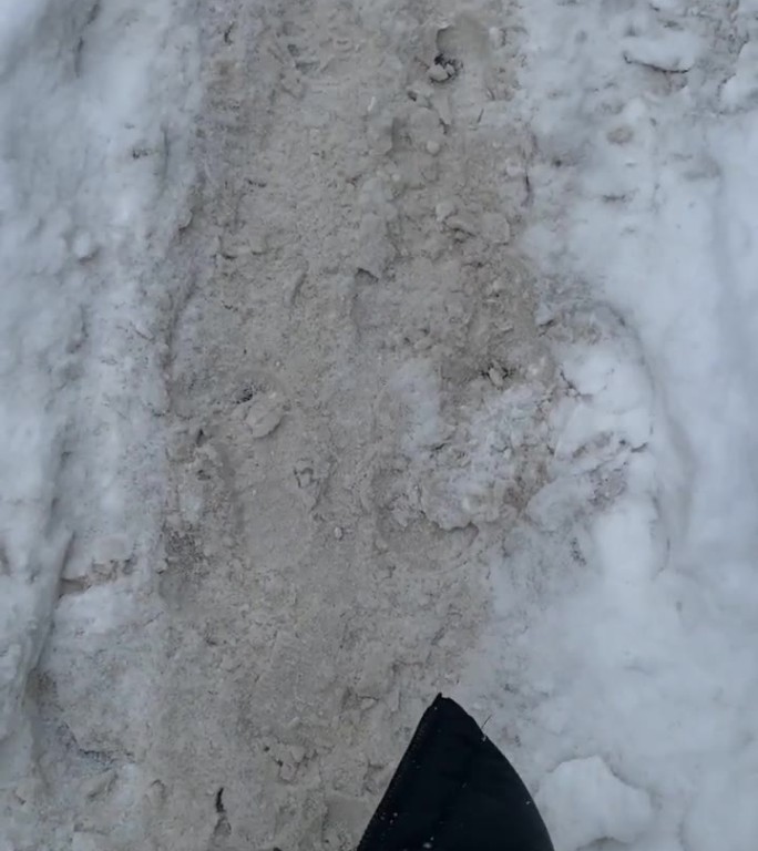暴风雪过后，女人的双腿在雪道上行走