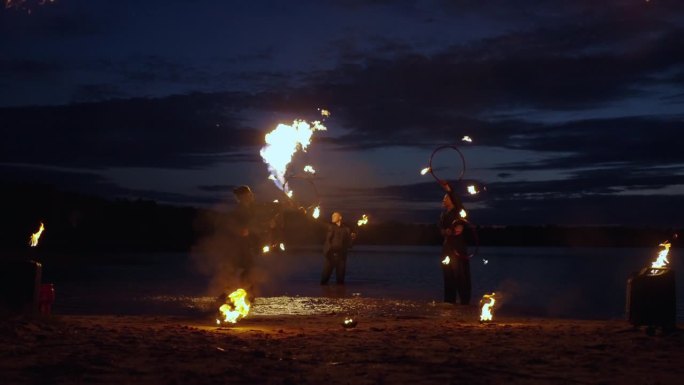 夜晚，马戏团演员在河边用火表演，专业人士在旋转火把
