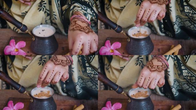 印度妇女用手在制作玛沙拉茶时加入香料。关闭了。