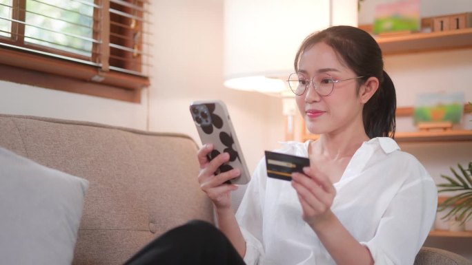 年轻的亚洲女性用手机在网上购物