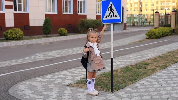 女学生在去学校或回家的人行横道上过马路，或者站在路标前用手指着它