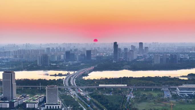 航拍夕阳高铁行驶桥梁河流车流建筑群高楼