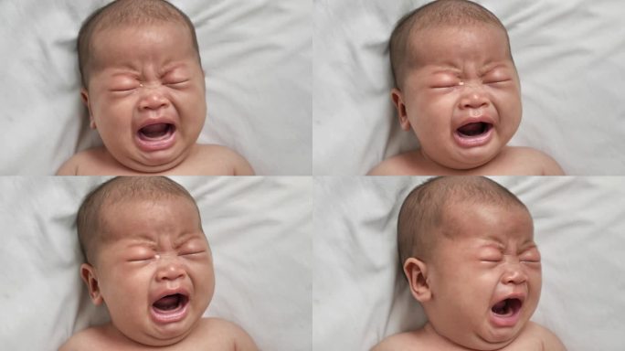 可爱的亚洲新生婴儿躺在床上哭泣的肖像