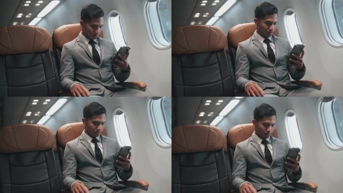 商务旅客乘飞机时使用手机。