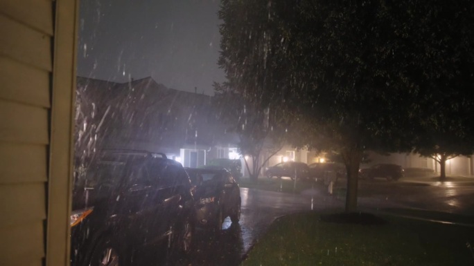 大雨暴雨落在家庭房屋附近的街道上。暴风雨之夜