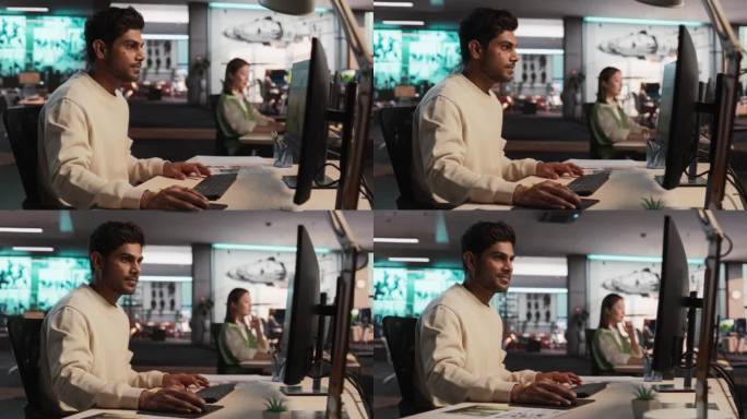 印度男性游戏开发者使用桌面电脑和3D建模软件为身临其境的生存视频游戏设计角色和世界。在游戏设计公司工