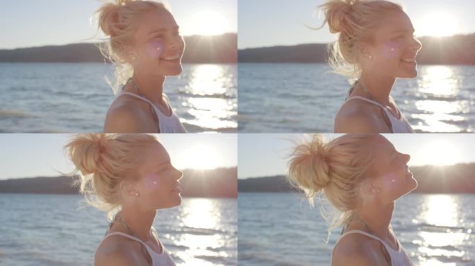 美丽的年轻女子在热带海滩上用手穿过风吹过的头发的特写镜头