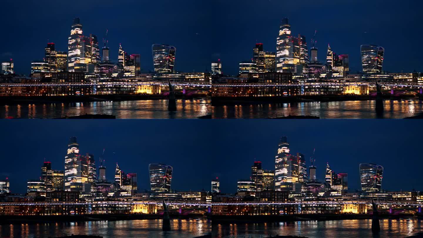 伦敦市中心的夜景，英国。市区的摩天大楼，泰晤士河上的千年桥，灯光明亮