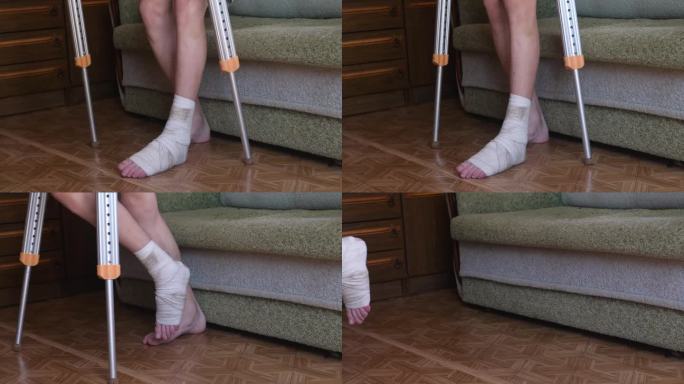 一名打了石膏的断腿男子借助拐杖在公寓里走动，因为四肢骨折暂时限制了他的活动