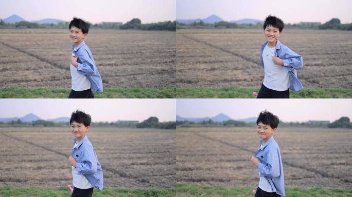 快乐的男孩行走在田野上慢镜头