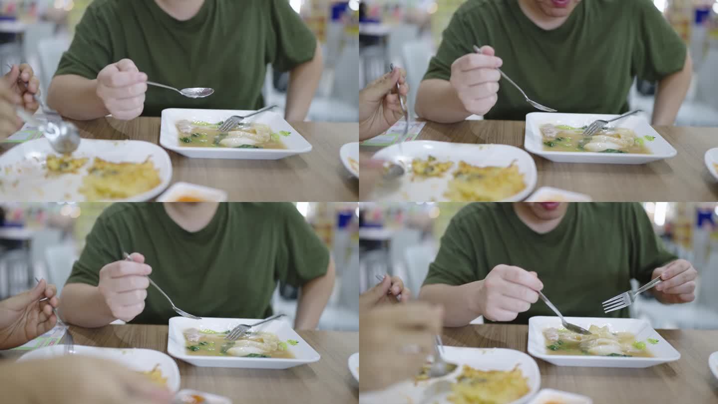 周末，一个胖乎乎的男人在泰国街头小吃摊吃饭，吃着浓汁炒米粉，而他的朋友们正在吃其他泰国菜。