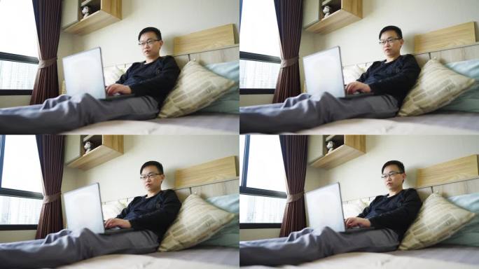 男人躺在床上用笔记本电脑工作