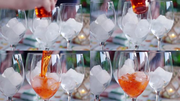 传统意大利aperol sprice的制作过程，在露天的朋友聚会上，调酒师将aperol倒入装有冰块