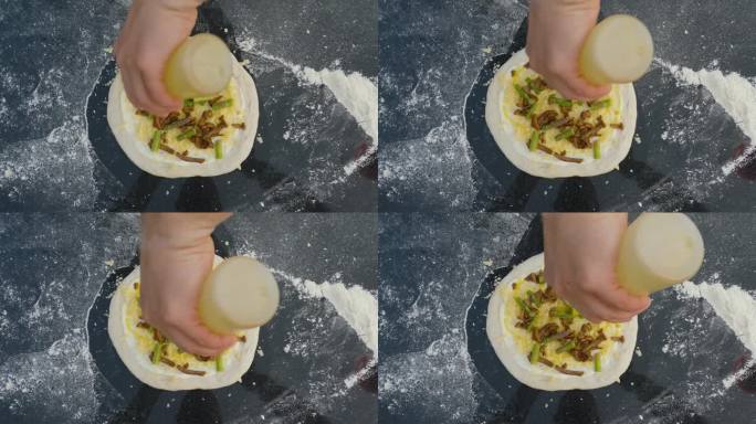 俯视图一位男厨师把橄榄油涂在他刚出炉的意大利披萨上。