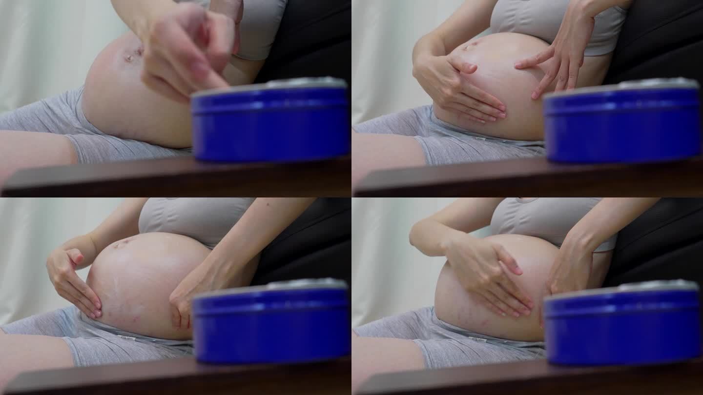 孕妇在大肚子上涂抹保湿霜。