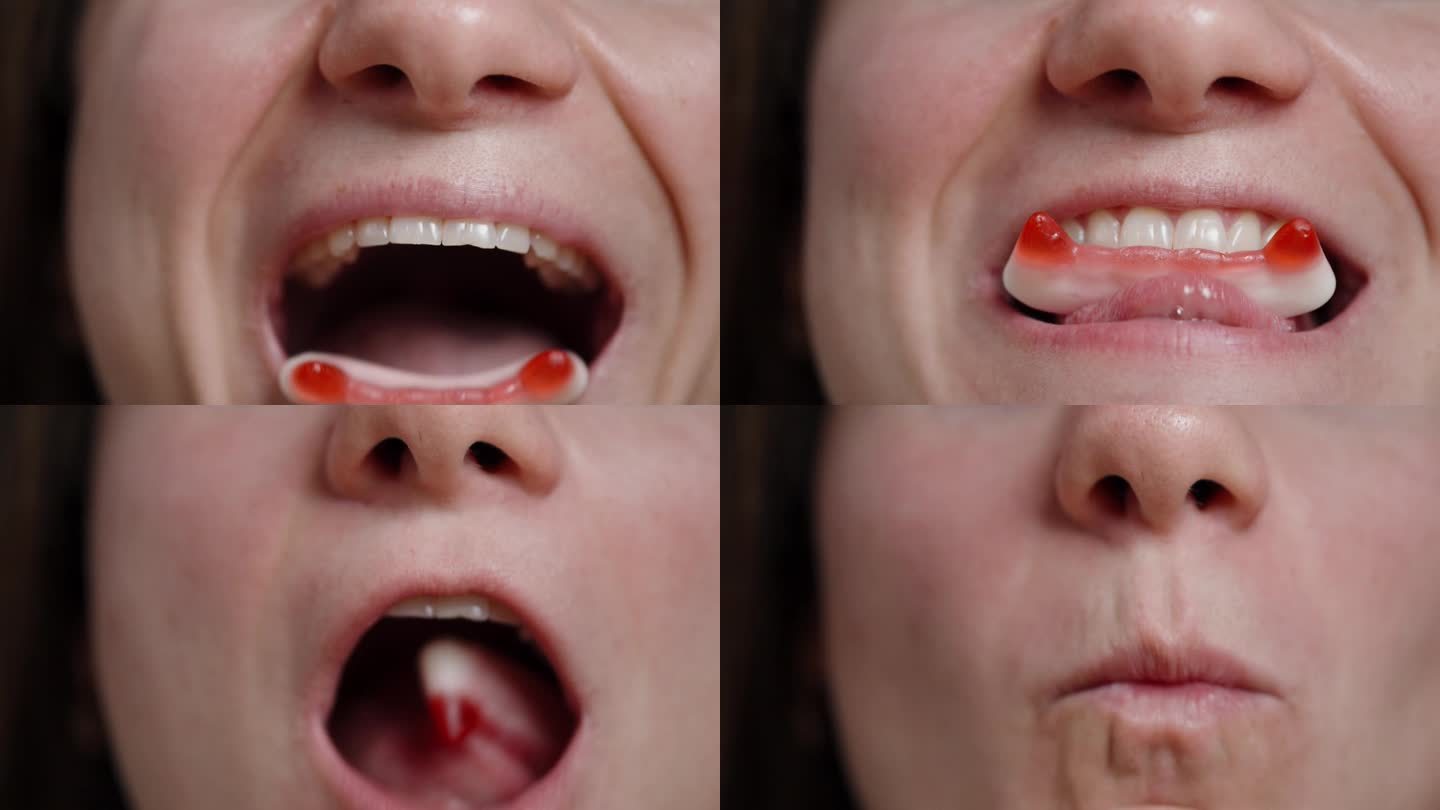 一个年轻女子吃着形状像红色吸血鬼尖牙的软糖，特写镜头。