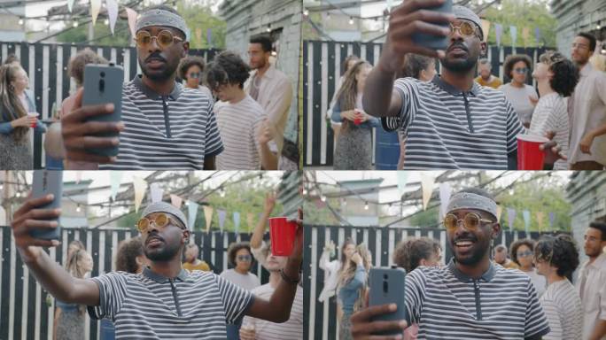 快乐的非洲裔美国人用智能手机进行视频通话，在街头咖啡馆的户外派对上聊天和跳舞