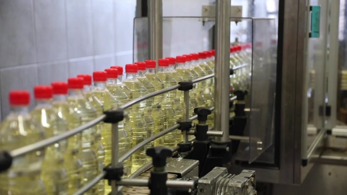 瓶装醋密封准备标签和包装上的传送带上的工厂正在生产一个角度的角度拍摄。