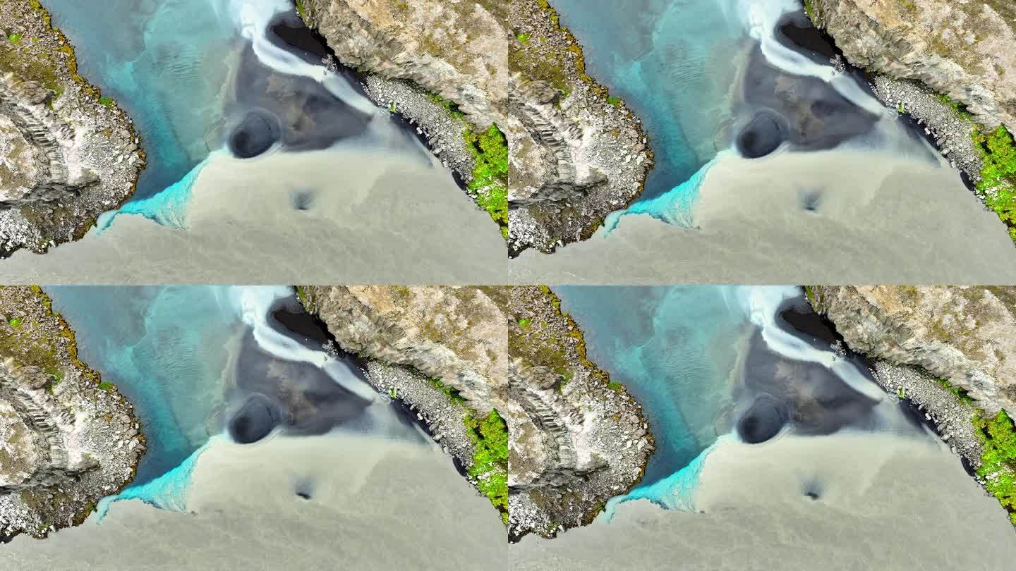 纯净的冰川绿松石水与浑浊的水混合，两条河流在冰岛混合，难以想象的景观与河流中的抽象图案。