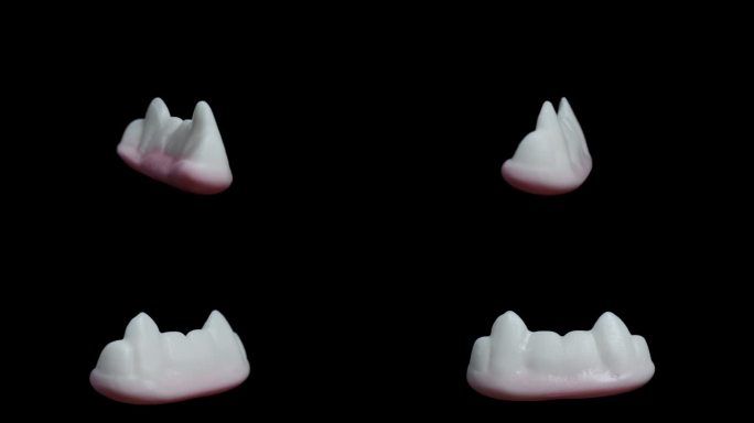 在一个特写镜头中，一个形状像白色牙齿和吸血鬼尖牙的软糖，在黑色背景上旋转，孤立的。