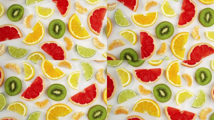 图案切片新鲜柑橘类水果柚子，橙子，柠檬，酸橙，猕猴桃旋转转孤立的白色背景接近您的顶部视图。健康的水果