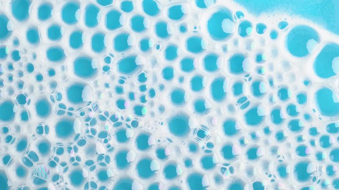 肥皂泡沫在蓝色的水面上冒泡。肥皂泡沫。背景灰尘泡沫与泡沫。运动中的肥皂