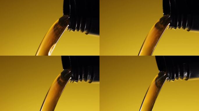 在黄色背景上从瓶子里倒入新车机油的特写。发动机维修