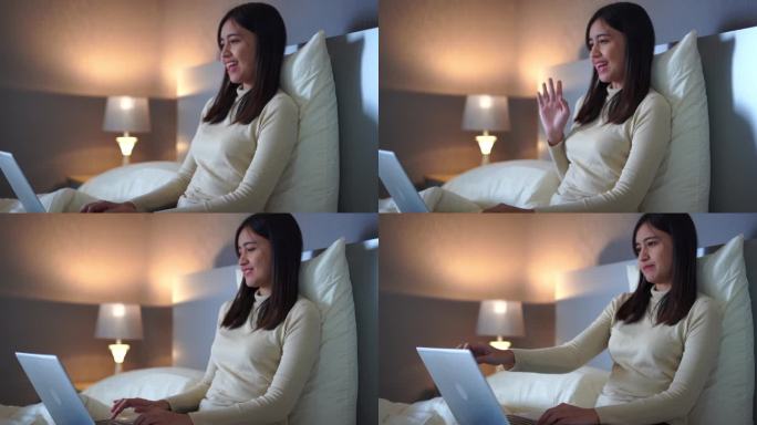 美丽的亚洲女人在笔记本电脑上开会，在她的卧室里以令人印象深刻的愉快情绪结束。